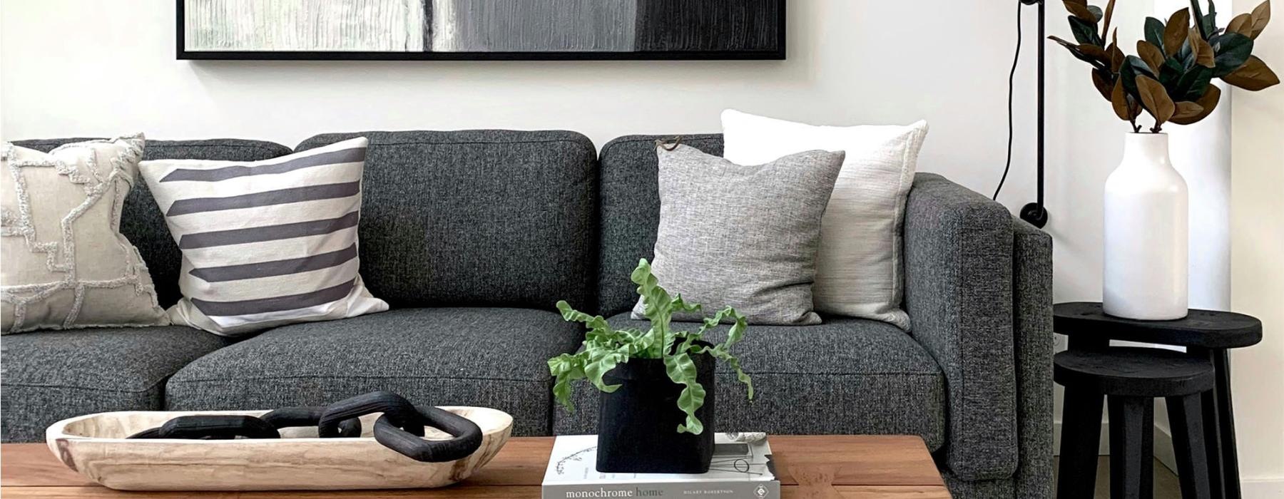 a couch with a coffee table with a plant and decor on it