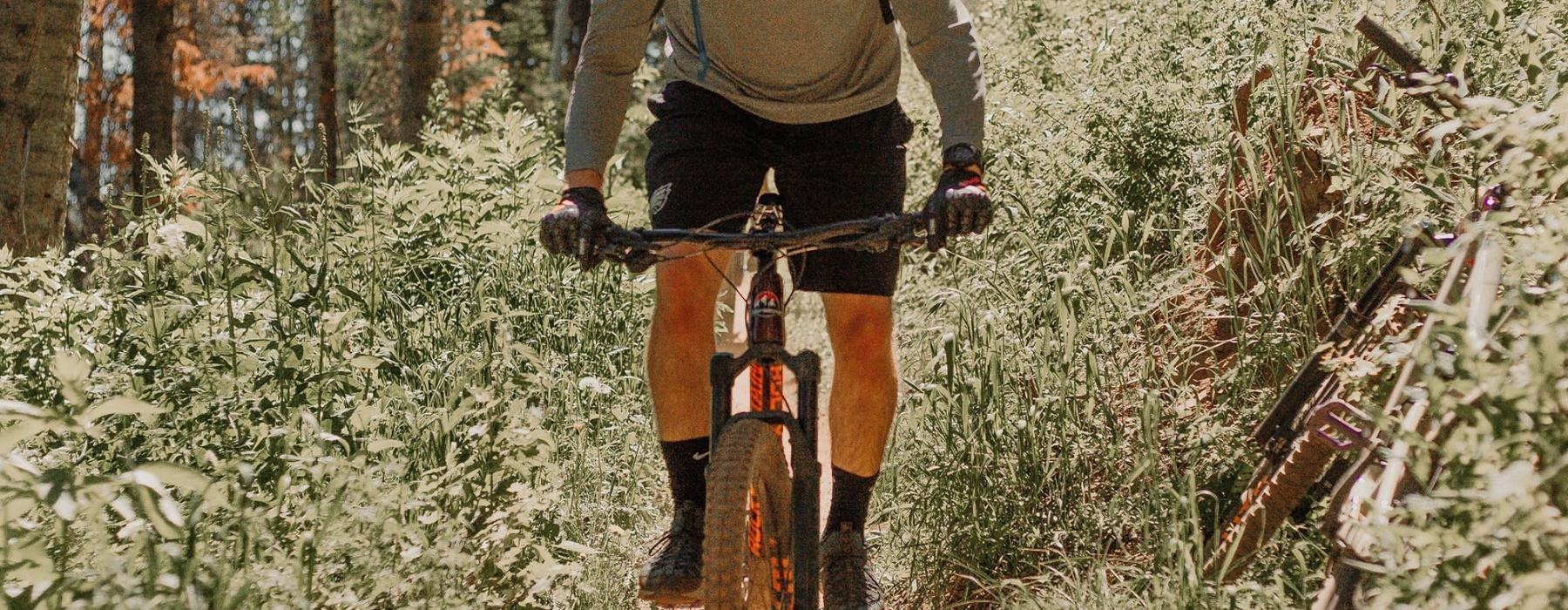 man riding a bike on a trail in the woods