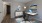 a room with a desk and a rug and a picture on a wall