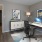 a room with a desk and a rug and a picture on a wall