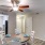 a dining table with a fan above it